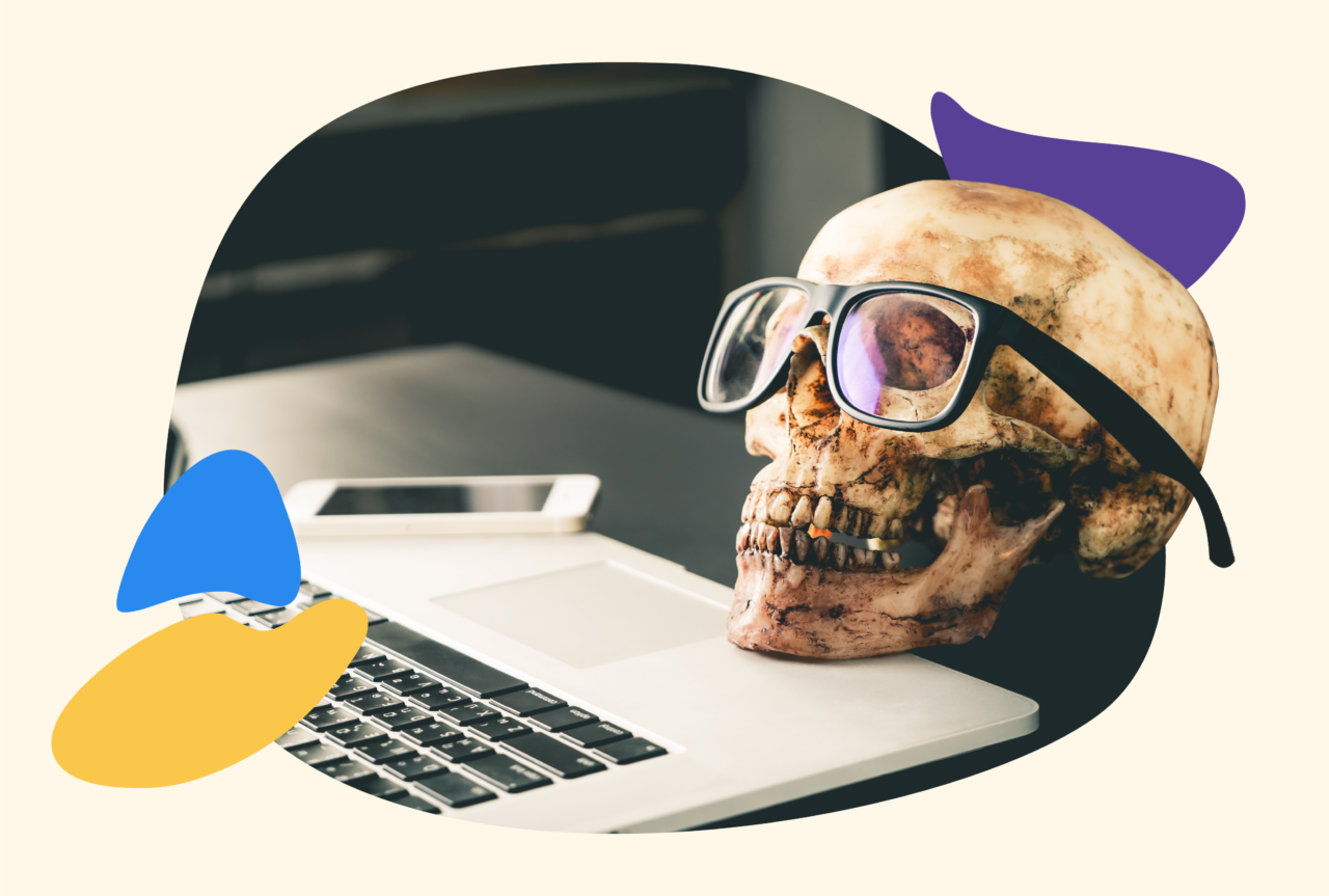 A skeleton head wearing glasses on a laptop keyboard