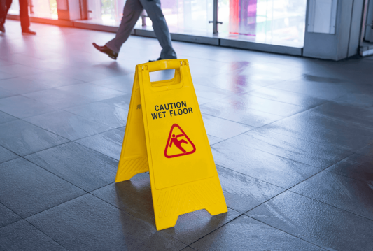 Yellow "Caution Wet Floor" sign in the middle of a hallway