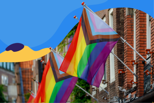 Two progress pride flags hanging off a brick stone building.